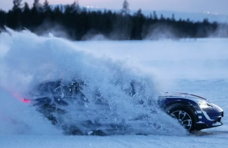 side view of a Porsche EV covered in snow