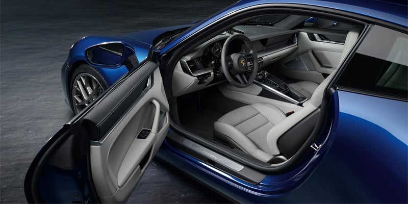 Blue Porsche 911 Targa 4S, driver's side door open revealing light gray and black interior.