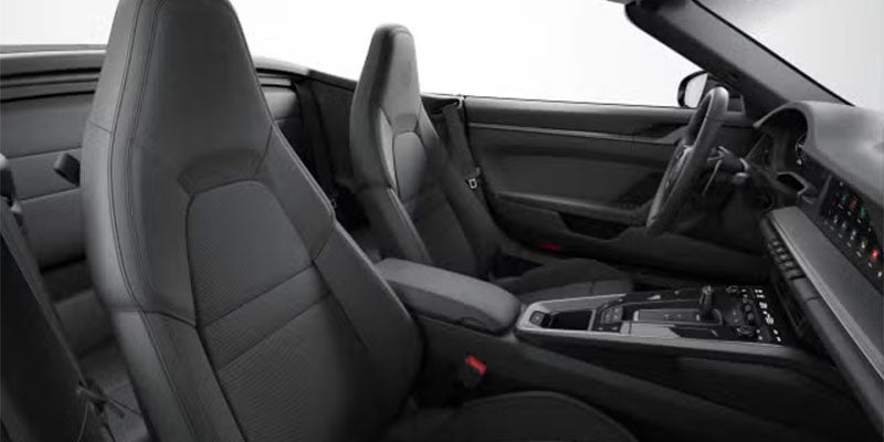 Interior view of a sleek black sports car with four seats, plush leather upholstery, and a modern dashboard.