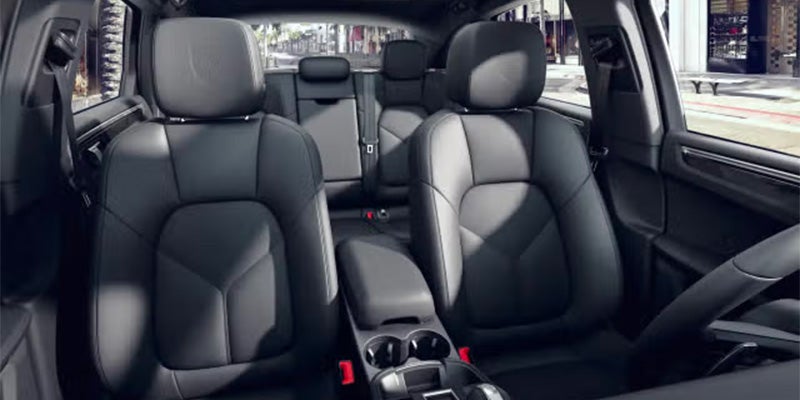 Interior shot of a car showing black leather front passenger seat, driver's seat, and back seats.