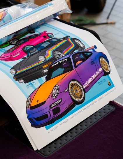 Several glossy posters display colorful illustrations of various Porsche cars.