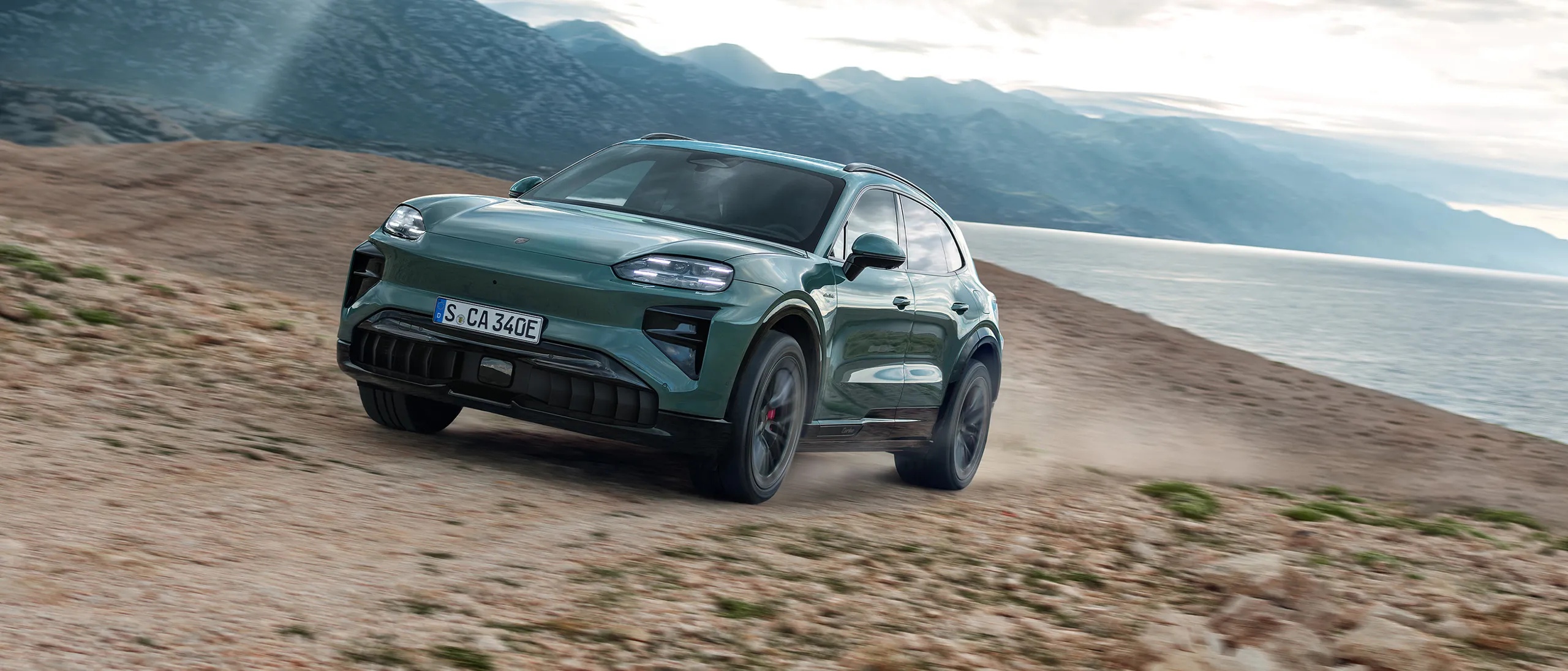 Porsche Cayenne driving on a mountain road.