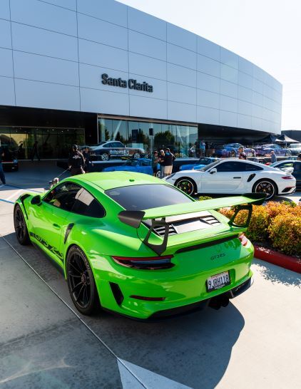 A bright green Porsche 911 GT3 sits parked outside a dealership in Santa Clarita, California.