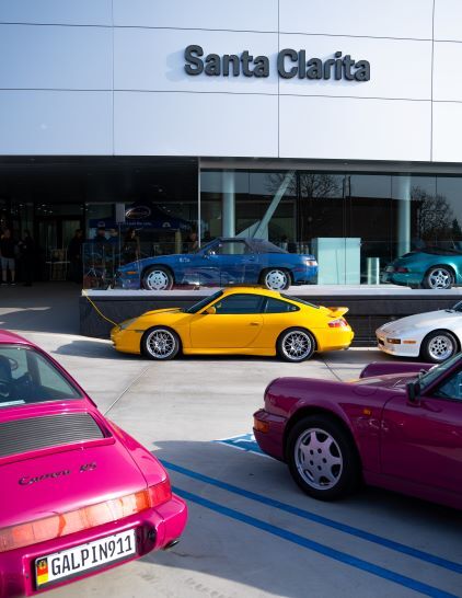 A bright yellow Porsche 911 sits on display outside a Santa Clarita car dealership.