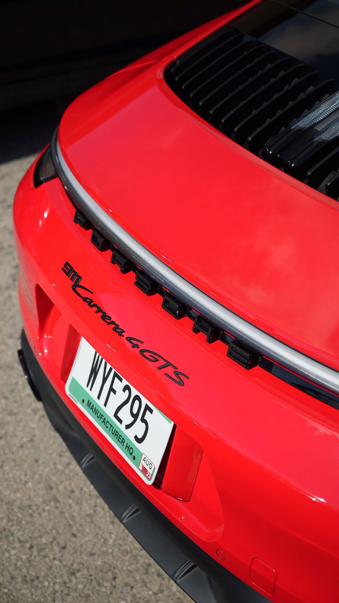 Rear view of a red Porsche 911 Carrera 4 GTS, showing black lettering and an Australian license plate.