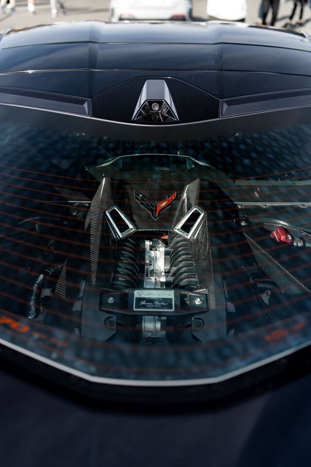 A sleek, black Lamborghini Aventador shows off its powerful V12 engine through a transparent engine cover.