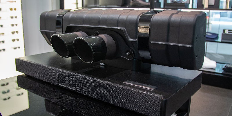 Black Porsche Design Soundbar with an integrated exhaust unit featuring two large, shiny black tailpipes.