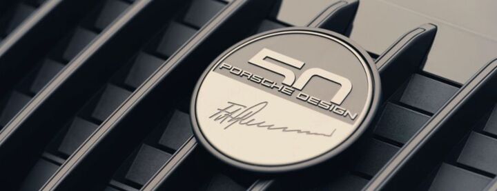 Porsche Design badge mounted on dark car grille with metallic finish