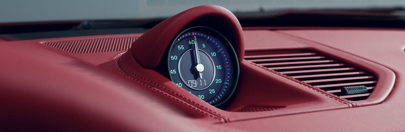 Close-up of Porsche dashboard clock set within red leather interior