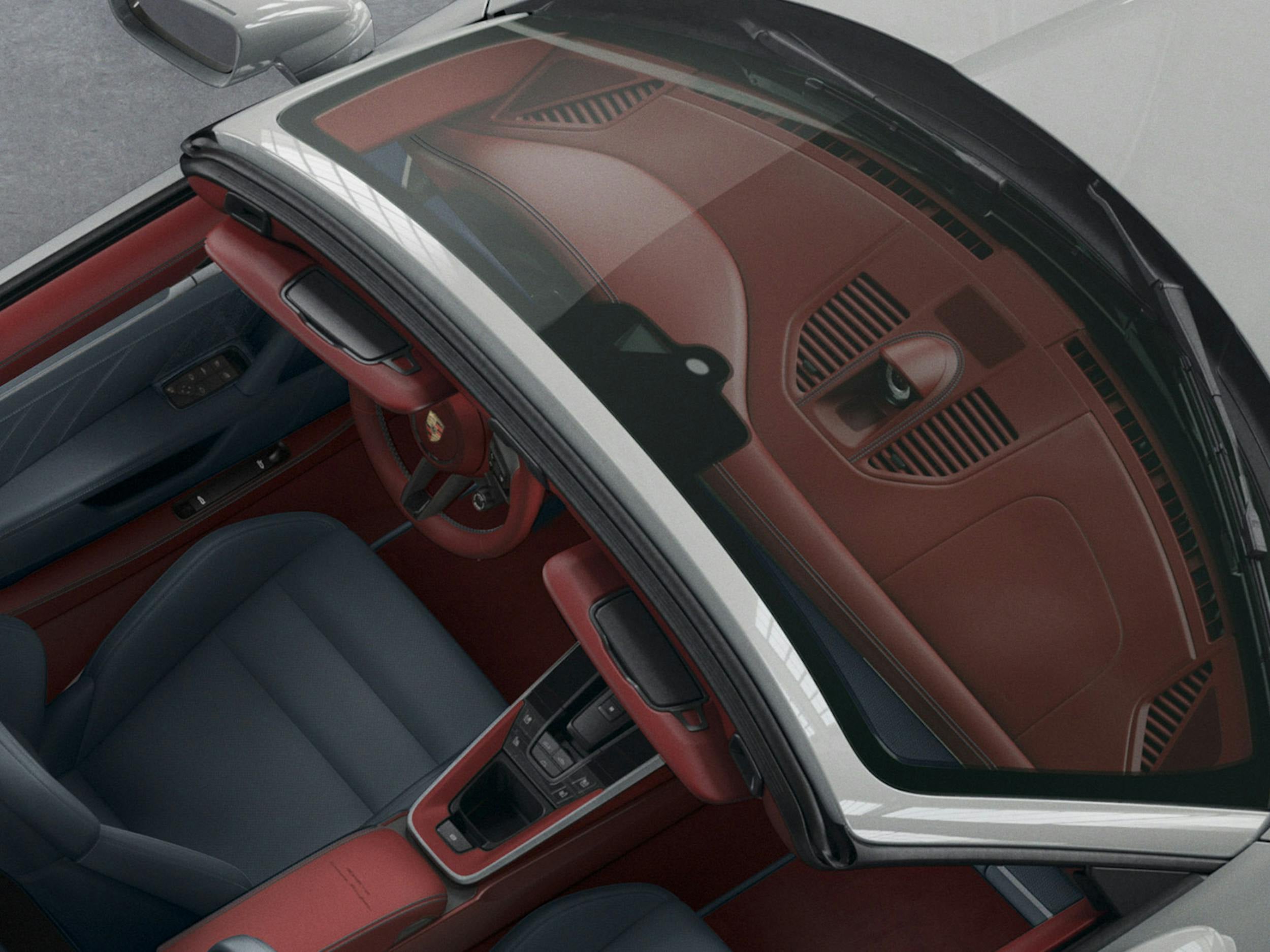 Interior view of a Porsche showing the windshield, dashboard and seating.
